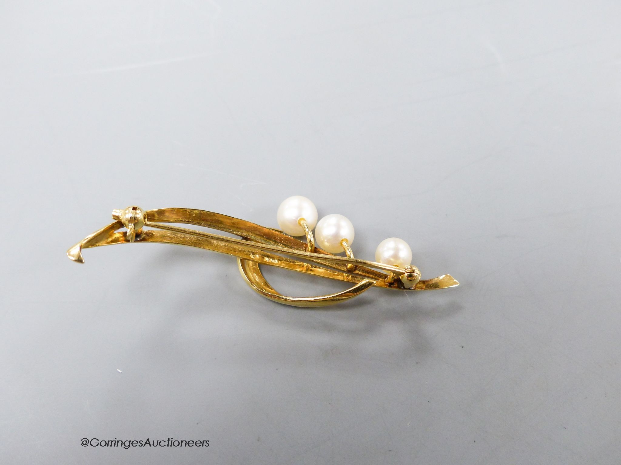 A yellow metal (stamped 14k) and three stone cultured pearl set spray brooch, 55mm, gross 5.2 grams.